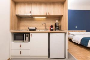 a kitchen with a sink and a microwave and a bed at Pantheon spuare view 3 in Komotini