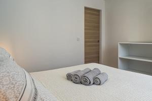 Una cama con tres toallas enrolladas. en L'Azuré-centre-ville/gare, neuf, en Châteauroux