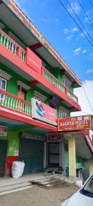 un edificio verde con letreros en el costado en Aajanta en Tawang