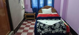 um pequeno quarto com uma cama com cabeceira em Aajanta em Tawang