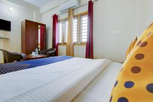 a bedroom with a bed and a table and chairs at SPOT ON Chandra's Residence in Dehradun