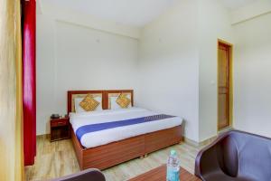 a bedroom with a bed and a chair in a room at SPOT ON Chandra's Residence in Dehradun