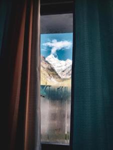 a view of a mountain from a window at Hotel Badrinath Anant Badrinath in Badrīnāth