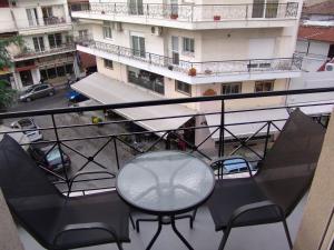 un balcón con mesa y sillas y un edificio en Kapsouli spuare 2, en Komotiní