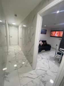 un vestíbulo con suelo de mármol y una habitación con sofá en THE ROYAL BOUTIQUE OXFORD LODGE by LONDON SLEEP 8 en Hayes