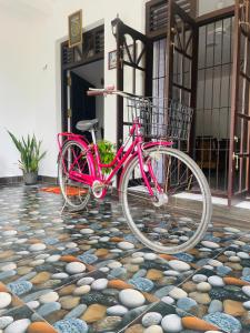 uma bicicleta rosa estacionada em frente a um edifício em Sri Mali em Matara