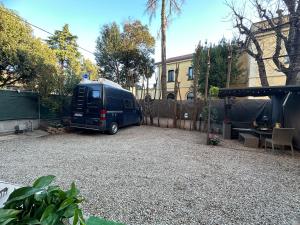 a blue van parked in a gravel parking lot at AB Suite Innovative Design in Bologna