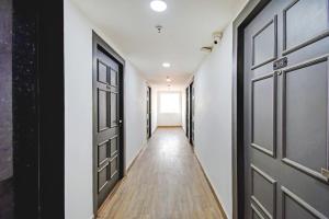 um corredor com portas pretas e pisos de madeira em Townhouse The Royal Retreat em Garui