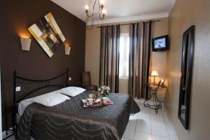Un dormitorio con una cama con una bandeja de comida. en Adonis Sanary Grand Hôtel des Bains en Sanary-sur-Mer