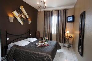 a bedroom with a bed with a tray of food on it at Adonis Sanary Grand Hôtel des Bains in Sanary-sur-Mer