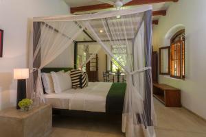1 dormitorio con cama con dosel en una habitación en MO River House Luxury Villa, en Hikkaduwa
