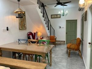 a living room with chairs and tables and a ceiling fan at Jessie Home in Bukit Mertajam +18 photos