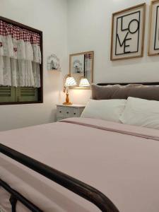 a bedroom with a white bed and a mirror at Jessie Home in Bukit Mertajam