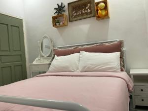 a bedroom with a pink bed and a mirror at Jessie Home in Bukit Mertajam