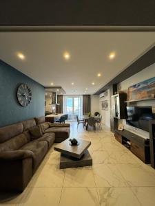 a living room with a couch and a clock on a wall at Designer 3 Bedroom / Bathroom Apartment in Swatar. in Birkirkara