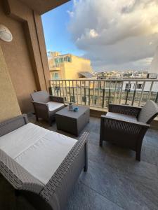 a balcony with chairs and tables on a building at Designer 3 Bedroom / Bathroom Apartment in Swatar. in Birkirkara