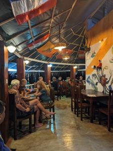 grupa ludzi siedzących przy stolikach w restauracji w obiekcie Little Pumpkin Cabanas w Tangalli