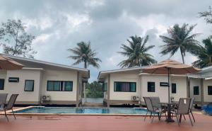 una villa con piscina, tavolo e sedie di Care Villa Koh Phangan a Ko Phangan