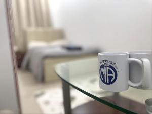 una tazza di caffè seduta sopra un tavolo di vetro di Heart of Abu Dhabi - Superb Room a Abu Dhabi