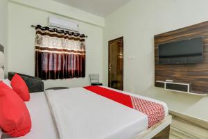 a bedroom with a bed and a flat screen tv at 75217 Hotel Navya Grand in Gulzārbāgh