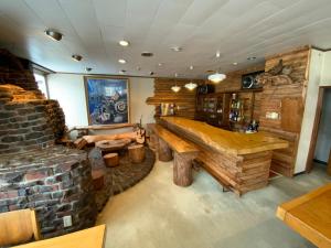 a room with a large wooden bench and a brick wall at ロッヂ　スガノ in Zao Onsen
