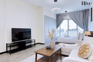 uma sala de estar com duas camas e uma televisão em Cosy Studio in Skycourts Tower no Dubai