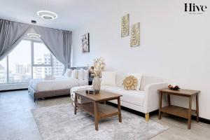 uma sala de estar com um sofá e uma cama em Cosy Studio in Skycourts Tower em Dubai