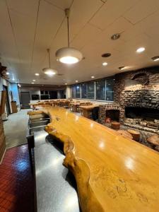 um bar com um longo banco de madeira num quarto em ロッヂ　スガノ em Zao Onsen