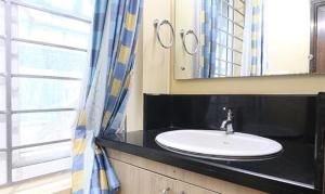 uma casa de banho com um lavatório e um espelho em FabHotel Elite Inn em Trivandrum