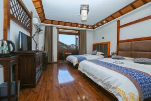 a hotel room with two beds and a television at Mountainside in Zhangjiajie