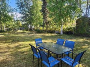 una mesa con sillas azules sentadas alrededor en un patio en *New* Centrally-Located Contemporary Retreat en Fairbanks