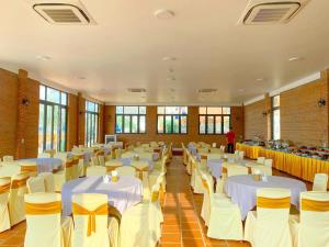 a banquet hall with white tables and chairs at Hon Rom 2 Resort in Mui Ne