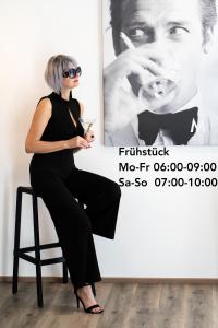 a woman sitting on a chair in front of a poster at Motel Schlafraum Schlüßlberg contactless check-in 