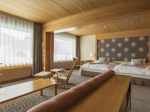 Habitación de hotel con 2 camas y escritorio en Shigakogen Prince Hotel, en Yamanouchi