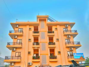 an orange building with balconies on it at Gulmohar inn in Lucknow