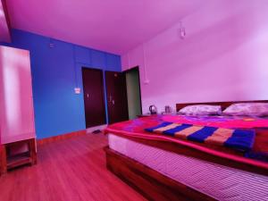 a bedroom with a bed with a red and blue hue at Hotel Paramount in Dentam
