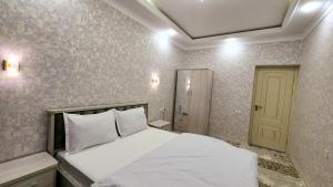 um quarto com uma cama branca e uma porta amarela em APARTMENT «СЕМЬЯ» em Tashkent
