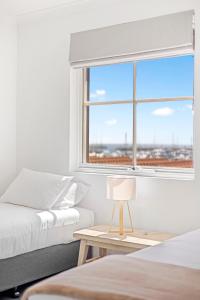 a bedroom with two beds and a window at Nautica Residences Hillarys in Perth