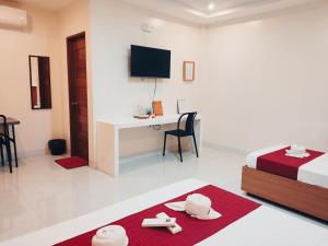 a bedroom with a bed and a desk with a tv at Aurelle Inn in Legazpi