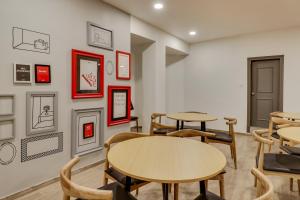 a room with tables and chairs and pictures on the wall at OYO Townhouse 591 Hotel Woodland in Nagpur