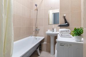 a bathroom with a bath tub and a sink at Апартаменты Expo Residents со всеми удобствами in Astana