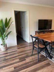 ein Esszimmer mit einem Holztisch und einer Topfpflanze in der Unterkunft Stylish 4 Bedroom Urban Retreat in Wagga Wagga