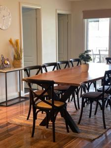 a dining room with a wooden table and chairs at Stylish 4 Bedroom Urban Retreat in Wagga Wagga