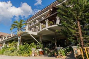 a building with a balcony and palm trees at Silver Naga Hotel in Vang Vieng
