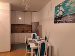 a kitchen and dining room with a table and chairs at Cozy Apartment in Lukavica