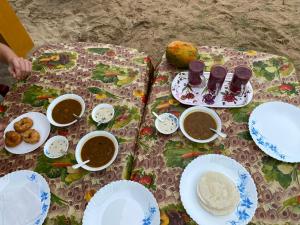una mesa con platos y tazones de comida. en Marari Sunset Beach Villa, en Alleppey