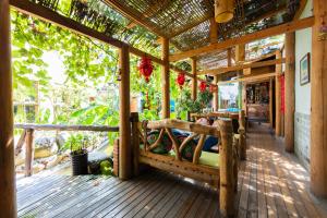 una veranda in legno con un letto su una terrazza di Butterfly Flowers Inn a Zhangjiajie