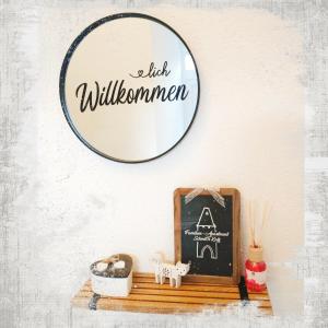 a mirror on a wall above a shelf with a chalkboard at Familien-Apartment SchmitTs Katz 