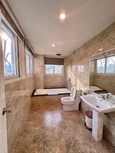 胡志明市的住宿－Paragon Hotel PMH，浴室配有卫生间、盥洗盆和浴缸。