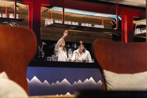 a woman standing at a bar with her hand in the air at Belambra Clubs Tignes Val Claret in Tignes +34 photos